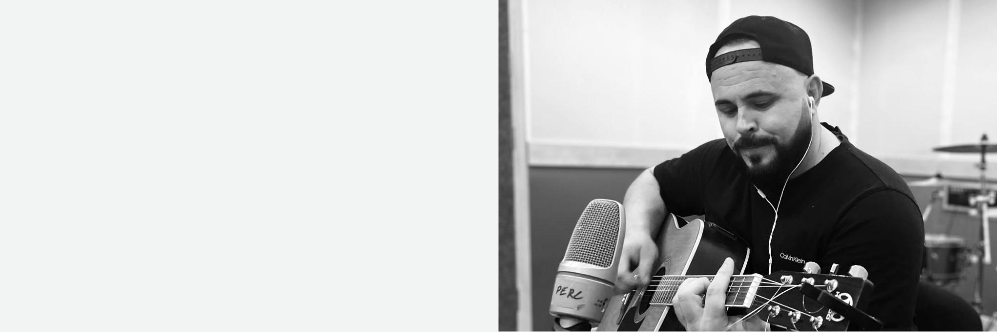 Rustam Nezhura playing acoustic ethnic instrument in ambient studio light